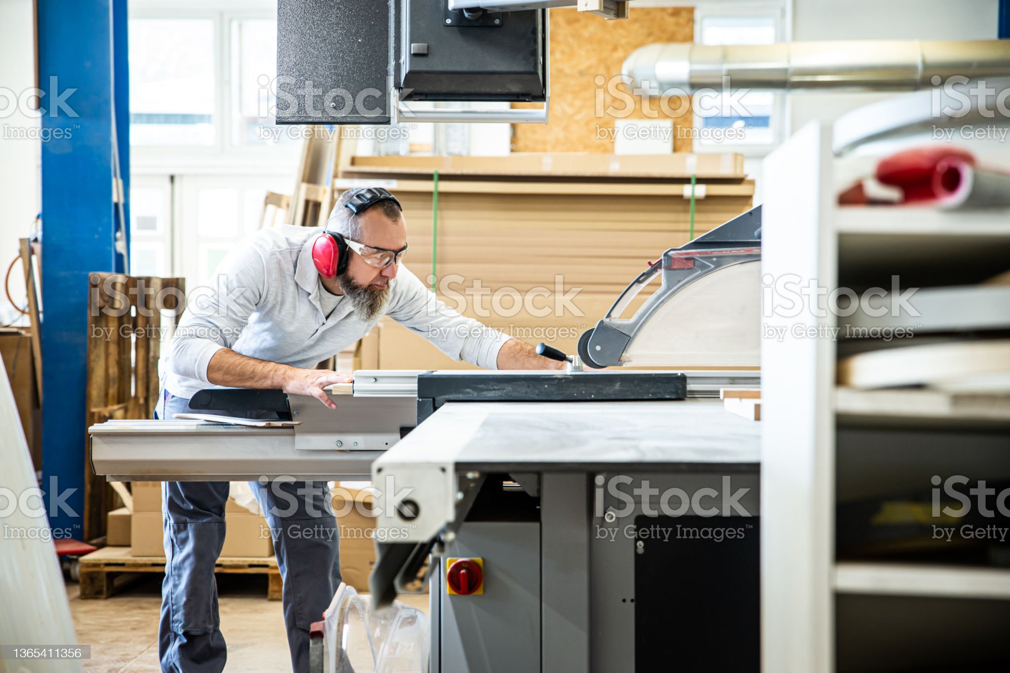 male craftsman saws wood on a circular saw, carpenter saws wood on a table saw in his workshop